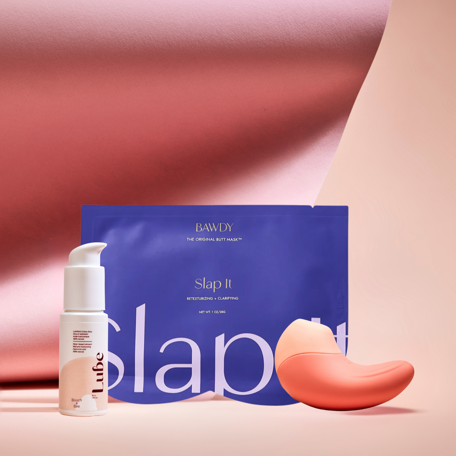 C'est une photo du coffret Badass avec Ona, stimulateur clitoridien vibrant de Bouche Bée, Lube, le lubrifiant 100% naturel à l'acide hyaluronique, le butt mask collection 4 masques de Bawdy, bleu, packaging posé sur des fesses