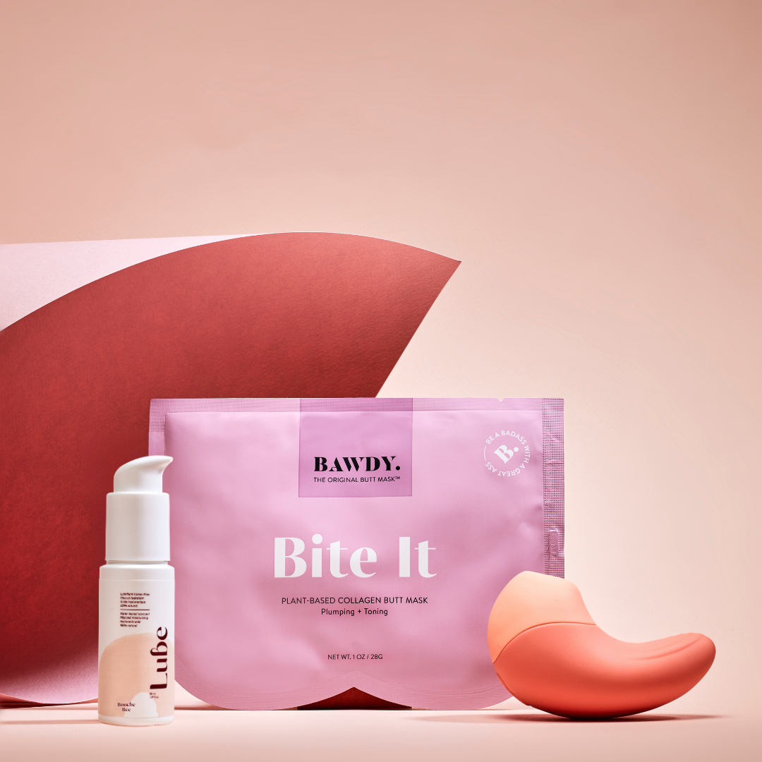 This is a photo of the Badass set with Ona, the vibrating clitoral stimulator from Bouche Bée, Lube, the 100% natural lubricant with hyaluronic acid, the butt mask collection 4 masks from Bawdy, yellow, packaging placed on the buttocks.